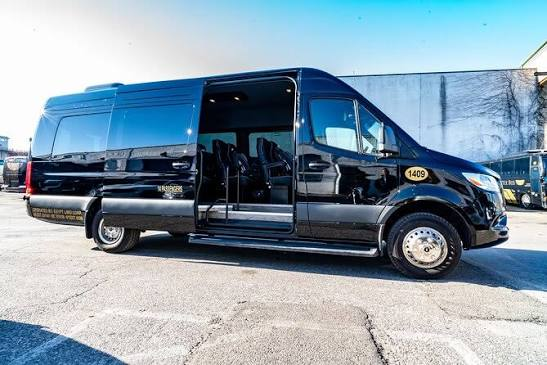 Black private transfer van with its door open, ready for guests