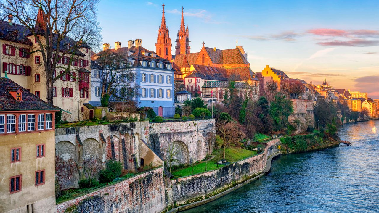 Basel old town and the red sandstone Munster towers glowing at sunset along the Rhine