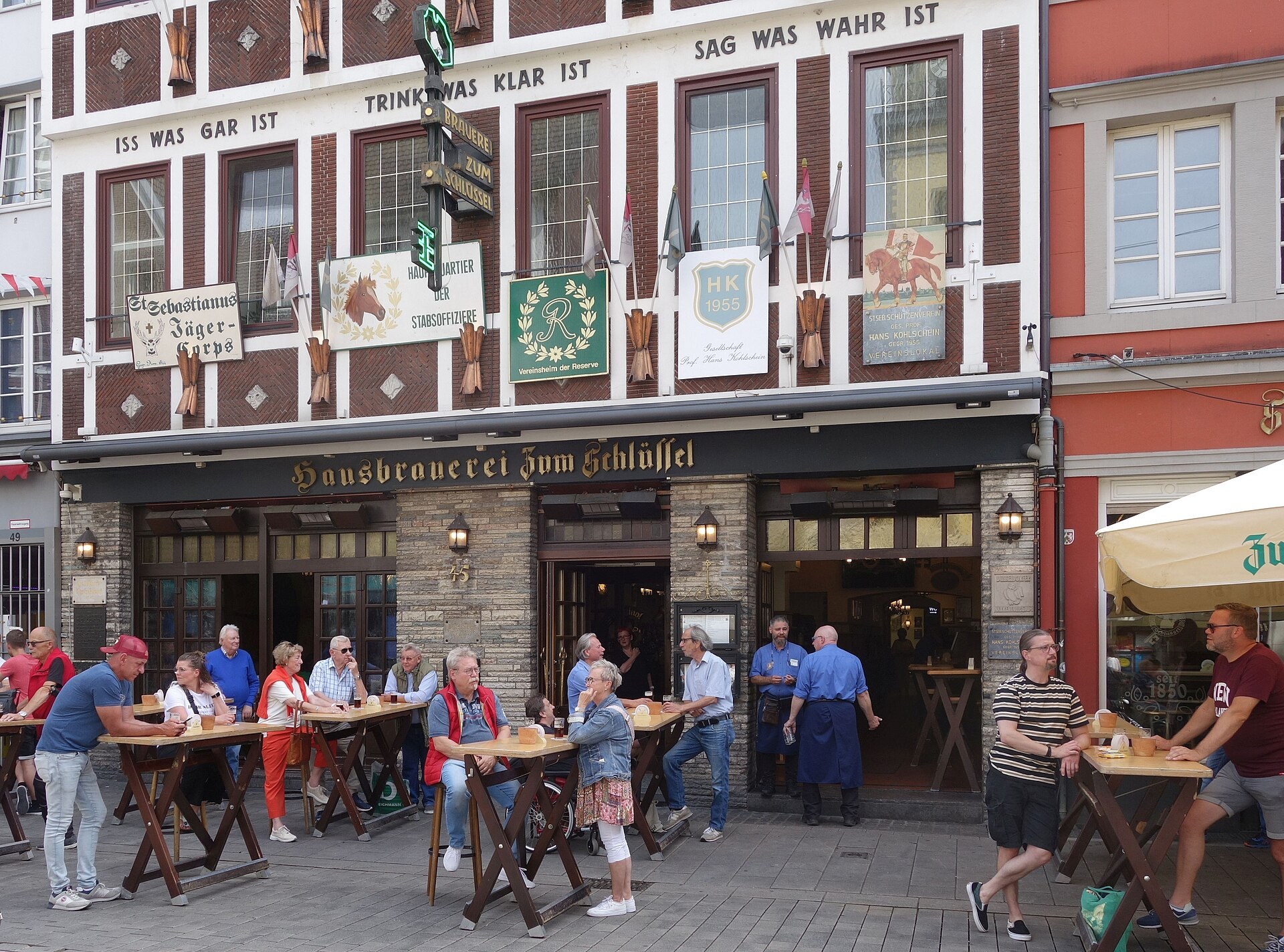 Guests with Altbier at standing tables outside a traditional Düsseldorf brewery